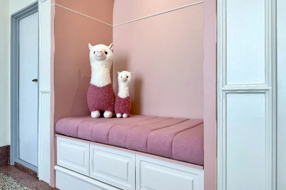 HRVRooms-Cezanne10 保羅.塞尚玫瑰房的臥榻設計與整體空間色系巧妙呼應,從牆面到擺飾皆延伸出濃淡相間、層次豐富的色彩序列。臥榻上靜靜坐著一對可愛的草泥馬玩偶,增添幾分溫暖與童趣氛圍。無論是情侶悠閒共度時光,或親子同遊共享幸福時刻,這裡都是理想且難忘的選擇。